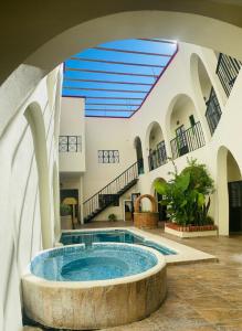 un gran edificio con bañera de hidromasaje en un patio en Hotel Doña Chela En Calvillo en Calvillo