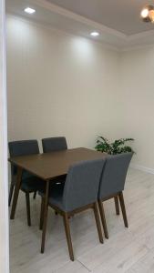 einem Holztisch mit vier Stühlen und einer Pflanze in der Unterkunft VIP квартира in Oral