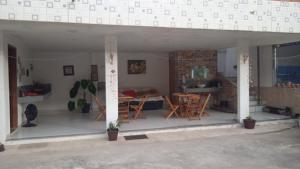salon i jadalnia ze stołem i krzesłami w obiekcie POUSADA MEGA w mieście Marataízes
