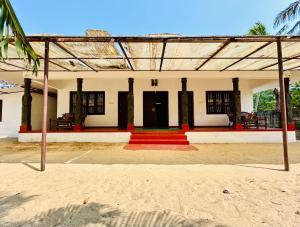 una casa con una alfombra roja delante de ella en Marari Beach Homestay, en Mararikulam