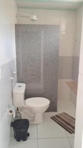 uma casa de banho com um WC branco e um chuveiro em POUSADA MEGA em Marataizes