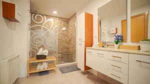 uma casa de banho com uma cabina de duche ao nível do chão ao lado de um lavatório em Only Women Guest House - Villa de la Comunidad Internacional de la Mujer em Olivella