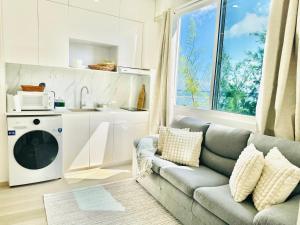 a living room with a couch and a microwave at Lazzlla beachside studio apartments in Hulhumale