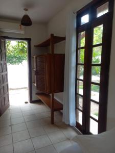 a room with a door open to a bedroom at pousada mandala in Cumuruxatiba