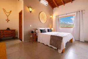 a bedroom with a large bed and a window at Solar da Matutina- Centro Histórico a 4 min da Rua do Lazer- Casa nova com piscina e vista maravilhosa in Pirenópolis +33 photos
