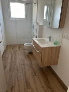 a bathroom with a sink and a toilet at Neubauwohnung gleich bei der Bushaltestelle - Apartment 2a in Vienna