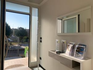uno specchio su un muro accanto a una porta con dei libri di VILLA BOEL Bergamo a Ponteranica
