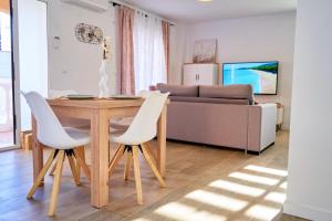 sala de estar con mesa de madera y sillas blancas en Rincón Marino Alto en Oliva