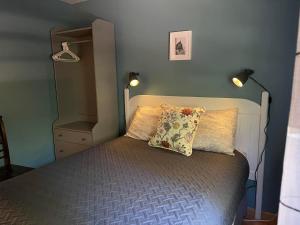 1 dormitorio con 1 cama con almohada y 2 luces en Forest & Lake PEI Cottages, en Murray Harbour