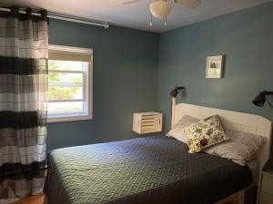 a bedroom with a bed and a window at Forest & Lake PEI Cottages in Murray Harbour