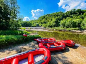 a group of inflatable boats sitting on the side of a river at APARTAMENTY Kolonia Leśna in Radków