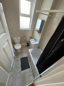 Baño pequeño con aseo y lavamanos en Kensington Guest Rooms 98, en Londres