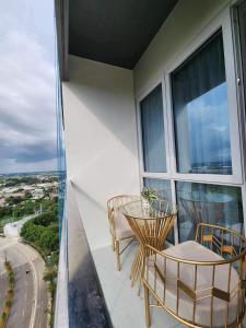 a balcony with two chairs and a table at The Palladium Iloilo near Convention Center Studio unit with private balcony in Iloilo City