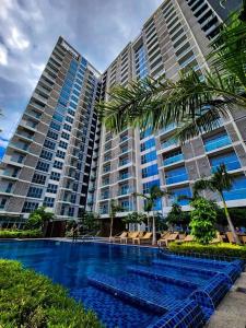 ein großes Gebäude mit einem Swimmingpool davor in der Unterkunft The Palladium Iloilo near Convention Center Studio unit with private balcony City View studio only in Iloilo City