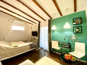 um quarto com uma cama e uma mesa com uma secretária em Avala Sunset Apartments em Belgrado
