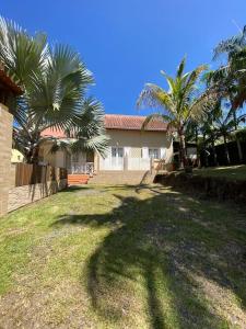 a yard with palm trees in front of a house at lé z'orangines in Saint-Benoît