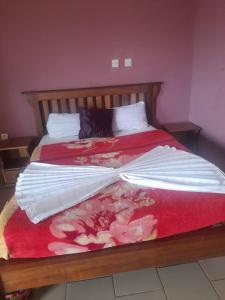 Un pat sau paturi într-o cameră la Britannia Hôtel Cmr