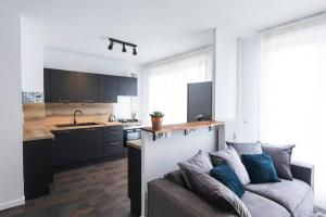 a living room with a couch and a kitchen at Appartement grande terrasse proche de Tours centre in Tours