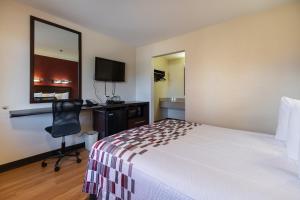 Habitación de hotel con cama, escritorio y silla en Sacramento Inn & Suites en Sacramento