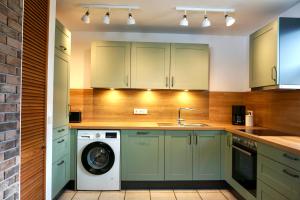 uma cozinha com armários verdes e uma máquina de lavar roupa em Haus Silvie 