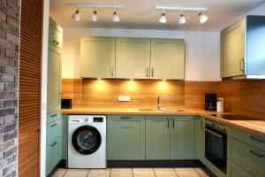 a kitchen with green cabinets and a washing machine at Haus Silvie 