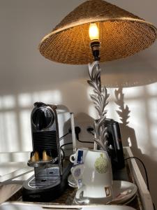 a lamp sitting on top of a counter with a coffee maker at Hôtel Le Neptune en Camargue in Saintes-Maries-de-la-Mer