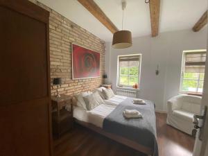 a bedroom with a bed and a brick wall at Villa Steffi in Lubań