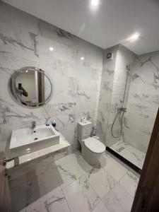 een badkamer met een wastafel, een toilet en een spiegel bij Appart haut standing coralia 14 in Oujda