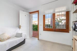 a white room with a bed and a window at Apartamento en S agaró zona tranquila in S'agaro