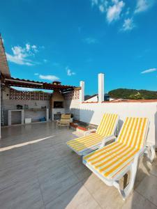 dos sillones sentados en el techo de una casa en Casa com Churrasqueira próx a Praia das Astúrias, en Guarujá