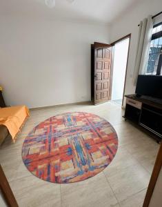 una sala de estar con una alfombra grande en el suelo en Casa com Churrasqueira próx a Praia das Astúrias, en Guarujá