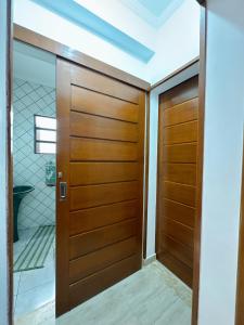 una puerta de madera en una habitación con baño en Casa com Churrasqueira próx a Praia das Astúrias, en Guarujá
