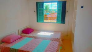 um quarto com 2 camas e uma janela em Privê Sol e Mar em Cabo de Santo Agostinho