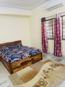 a bedroom with a bed and two windows at Home Stay Near Kolkata Airport in kolkata