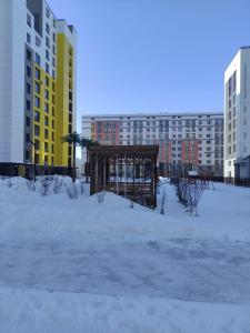 a park covered in snow in front of tall buildings at Miami in Taldykolʼ