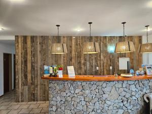 a bar with a stone counter with lights above it at Hotel Sur Sur Patagónico in Esquel