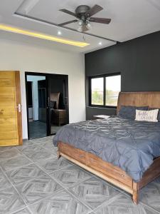 1 dormitorio con 1 cama y ventilador de techo en Villa Serenity with Swimming Pool, Home Theater, and Gym, en Baguida