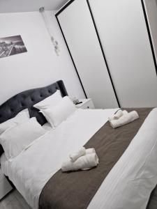 ein Schlafzimmer mit einem großen weißen Bett mit Handtüchern darauf in der Unterkunft TAG Apartament in Timişoara