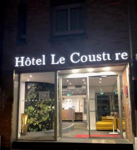un signo de conjetura de hotel frente a una tienda en Hôtel Le Cousture en Toulouse