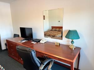 una oficina con escritorio, ordenador y espejo en White River Motel, en White River