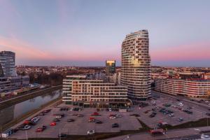 a city with a parking lot and a tall building at Emihouse Riverside Apartments in Rzeszów