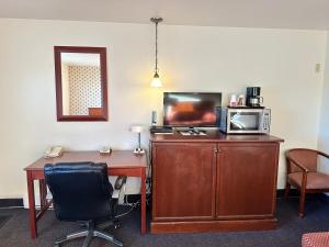 een bureau met een magnetron en een tafel bij White River Motel in White River