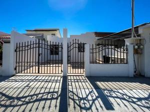 a gate in front of a white house at Comfortable family friendly Home 133 in Puerto Peñasco