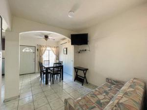 Comfortable family friendly Home 133 في بورتو بيناسكو: غرفة معيشة مع طاولة وغرفة طعام