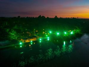 uma vista para um rio à noite com luzes em Ciamat Camp em Santo Amaro