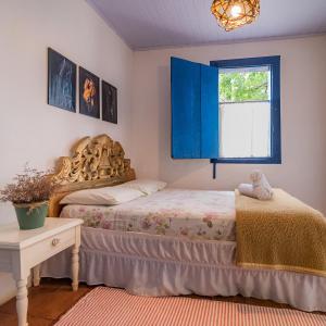 Schlafzimmer mit einem Bett und einem Fenster in der Unterkunft Reduto das Artes Hostel pousada in Casa Branca