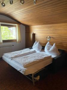 1 dormitorio con 1 cama grande y pared de madera en Ferienwohnungen Vierthaler, en Filzmoos