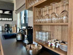 a kitchen counter with glasses and cups on a shelf at Villa Vinova Loza in Kaštelir