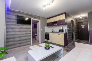 a living room with a white couch and a table at Апартаменти Елеганс in Sandanski