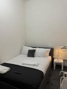 a large bed with white sheets and pillows on it at 4 Bedroom Entire Flat, Kings Cross Road in London